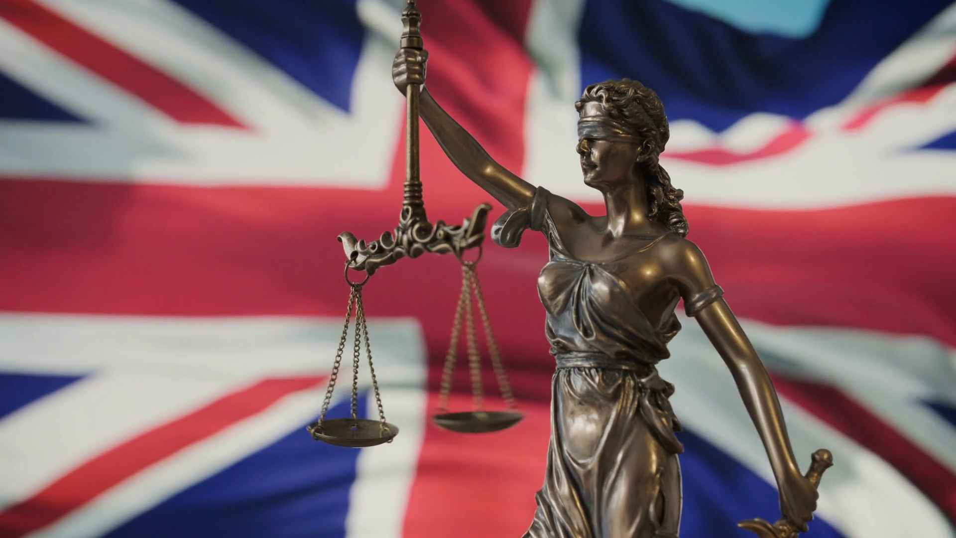 lady-justice-statue-with-uk-flag-background-stock-footage-sbv-352099160