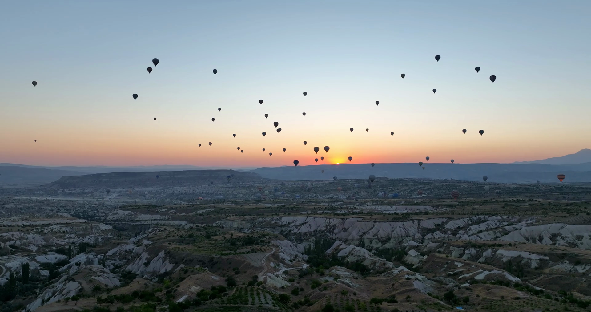 Aerial cinematic drone view of colorful hot air balloon flying over ...