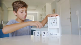 Boy Changing the date on the wooden calendar on February 14 or Valentines day.