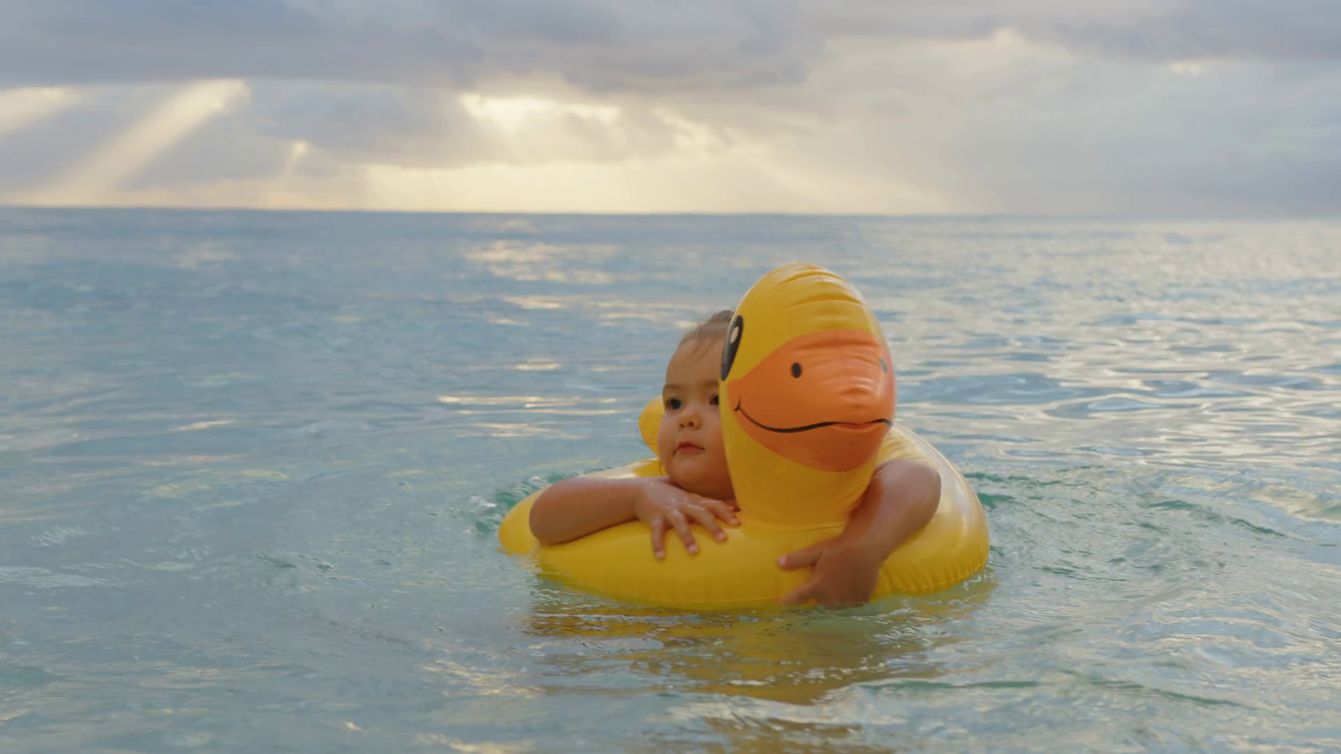 Portrait of little baby floating on an inflatable duck in the Indian