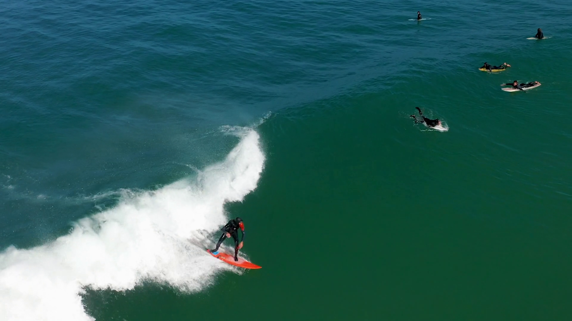 Aerial shot male surfer catches and ride a massive barreling waves