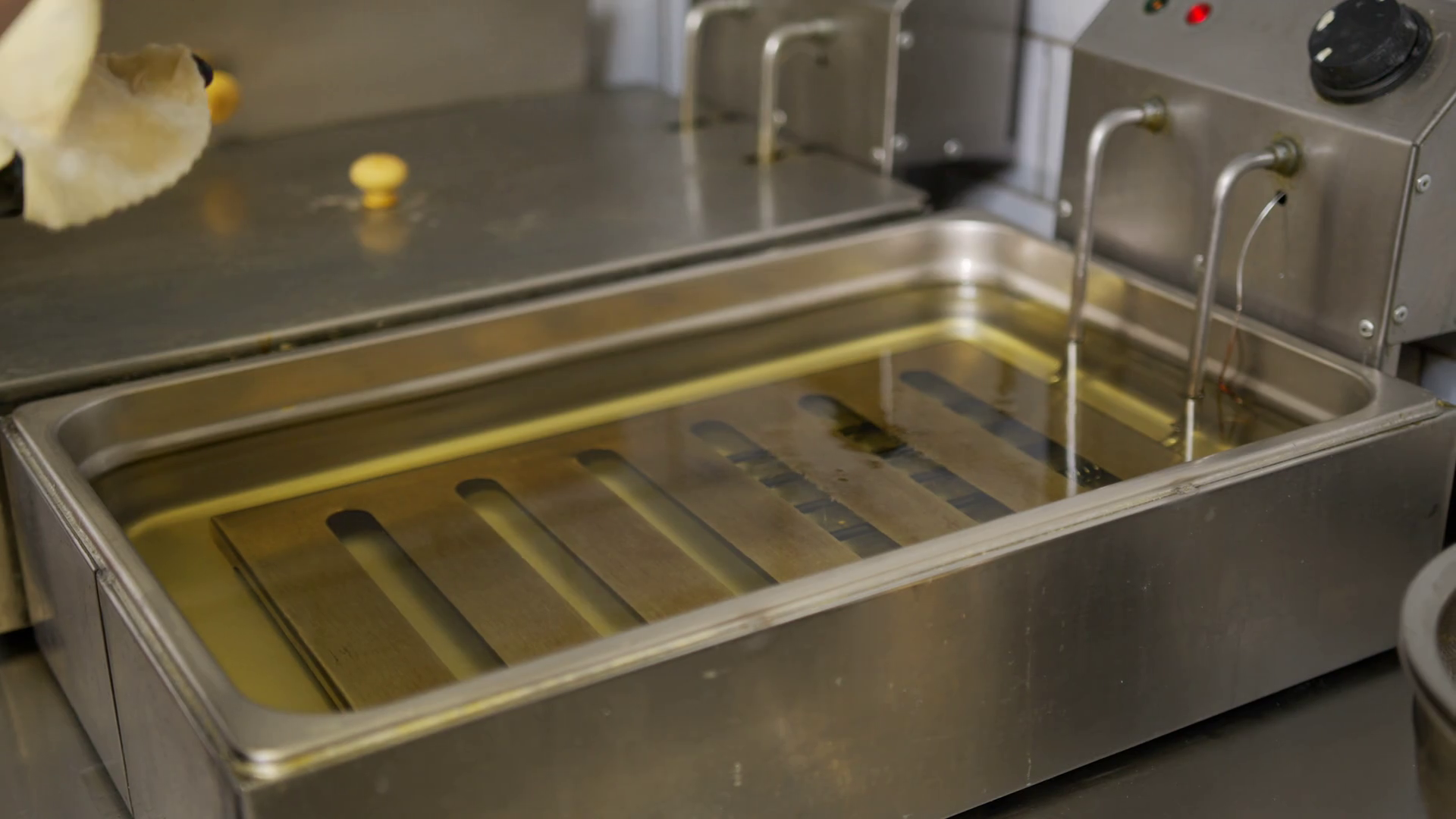 Cooking oil boiling and bubbling in fryer for deep frying dishes in a