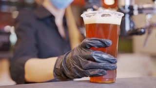 Pouring cold beer into glass. Bartender pouring craft beer in the bar. The hand of a master brewer pour from keg a light draft beer foam . Stout, Light, Unfiltered beer, ready to drink . Slow motion.