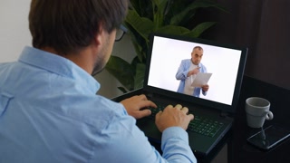 Student studying math online from home, taking notes and following professor's lesson on video call