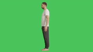 Long Shot of a Bare Foot Man Wearing T-Shirt and Sweatpants while Camera Rotates Around Him. Shot on a Green Screen Background.