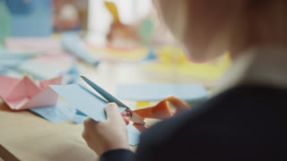 Girl Has Fun on the Handicraft Project, Cuts Paper Figures with Scissors