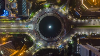 Aerial Birds Eye Overhead Top Down View hyperlapse of busy car traffic on roundabout around Selamat Datang monument in Jakarta at night, motion time lapse hyper lapse
