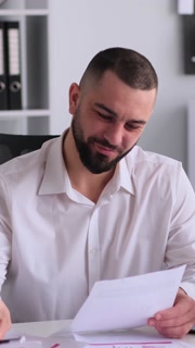 Smiling Employee Engaged In Paperwork And Planning Business Strategy In Office