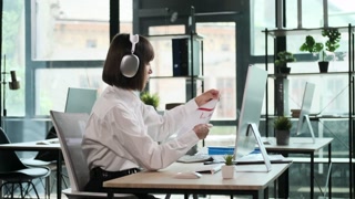 Businesswoman in Headphones Conducting Video Conference with Documents