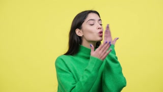 Positive Caucasian Woman Sending Air Kisses on Yellow Background
