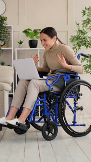 Disabled Woman in a Wheelchair Having a Video Call on a Laptop
