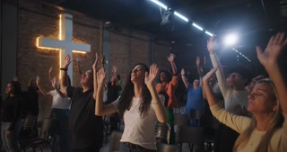 People raising hands in church, African descent, spiritual connection, prayerful worship, community gathering, faith, emotional expression, uplifting moment