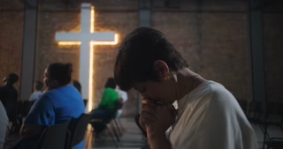 Woman in church praying with closed eyes, hands clasped, deep emotional engagement, Christian spirituality, worship service, faith connection, peace