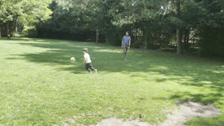 Sunny Day Connection and Fun - Child Playing Ball with Dad on the Grass