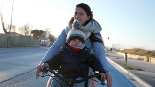 Mother Riding Bicycle With Child Seated In Front Parent Commuting During Cold Winter Day Rides Bike In City 5