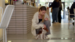 Woman petting dog in indoor cafe