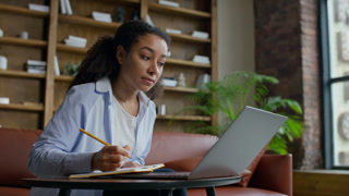 Woman Taking Notes During Online Lesson