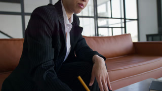 Businesswoman taking notes during online class
