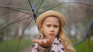 A cheerful girl joyfully holding an umbrella, capturing the delightful charm of a rainy day in a scenic park