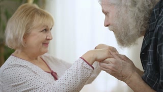 Loving senior couple sharing affection at home.