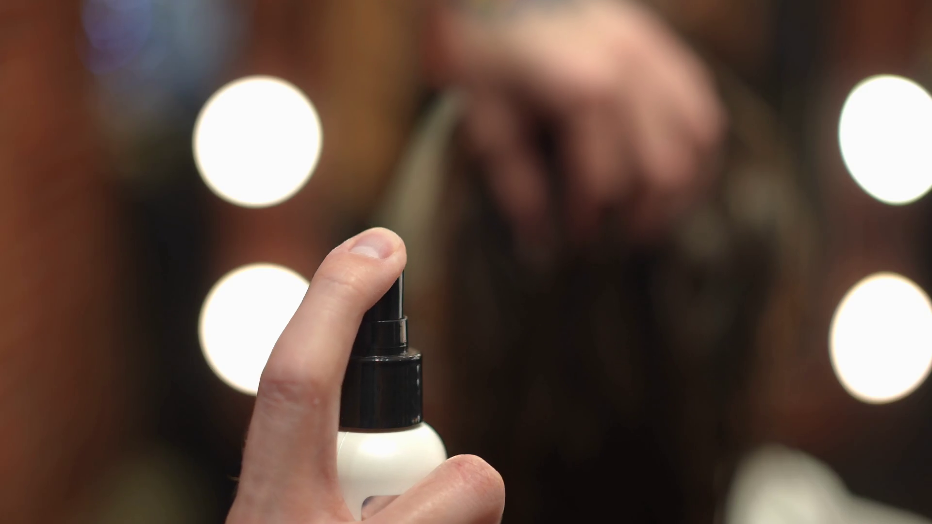 Closeup spraying hair fixation spray in slow motion indoors