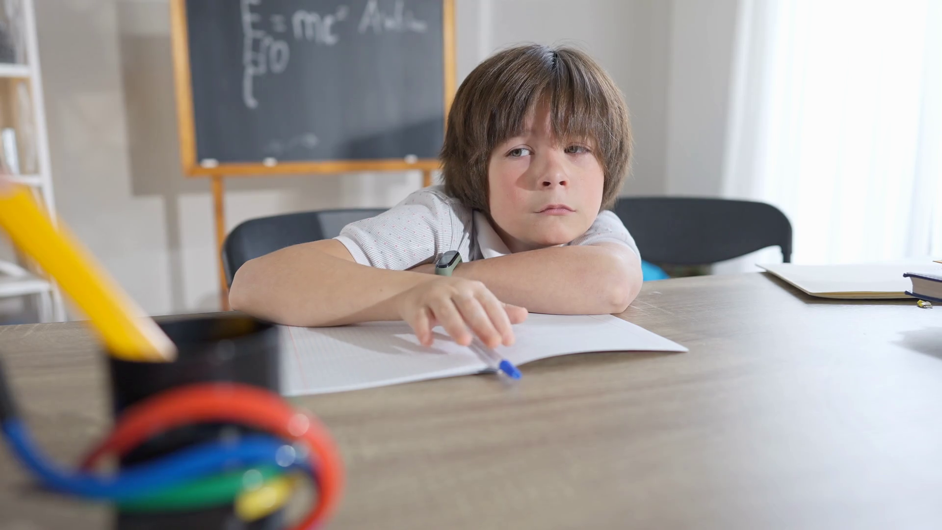 Caucasian schoolboy crying at desk in classroom. Portrait of