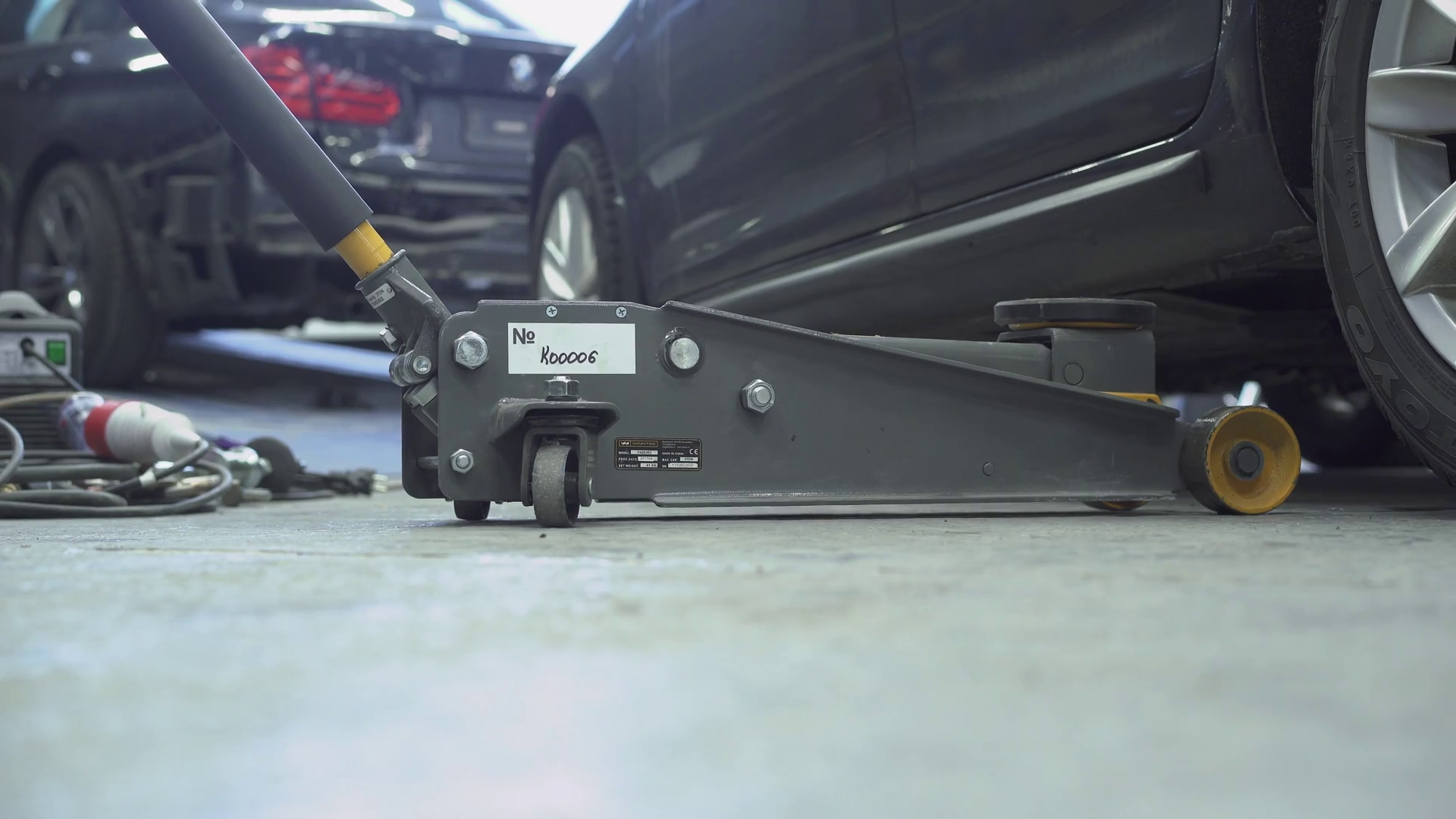Car specialist raising the back of the car with a jack to make