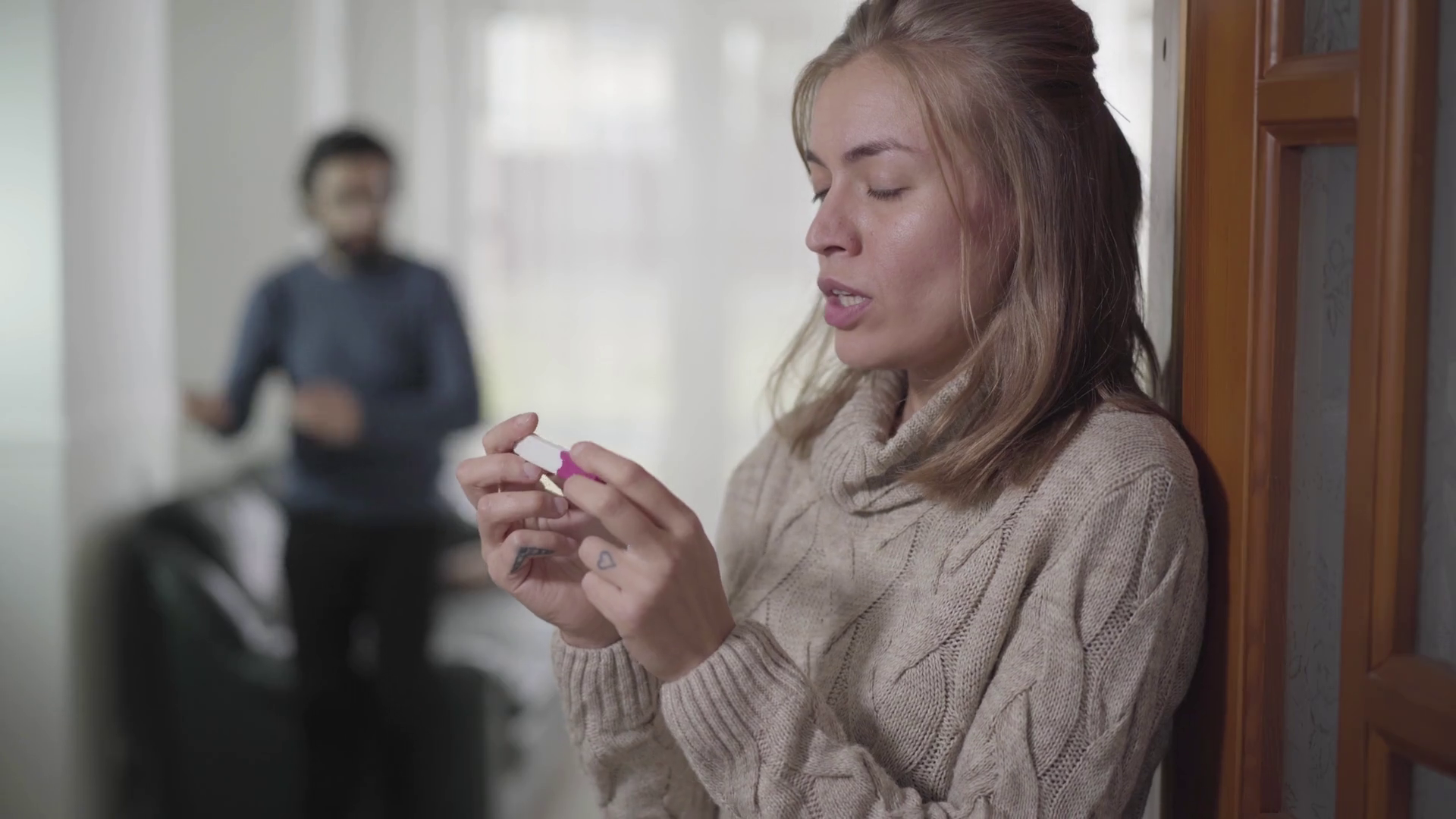 Closeup face of exhausted Caucasian woman standing with pregnancy test