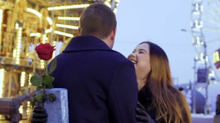 Happy in love couple kissing and hugging at carousel background