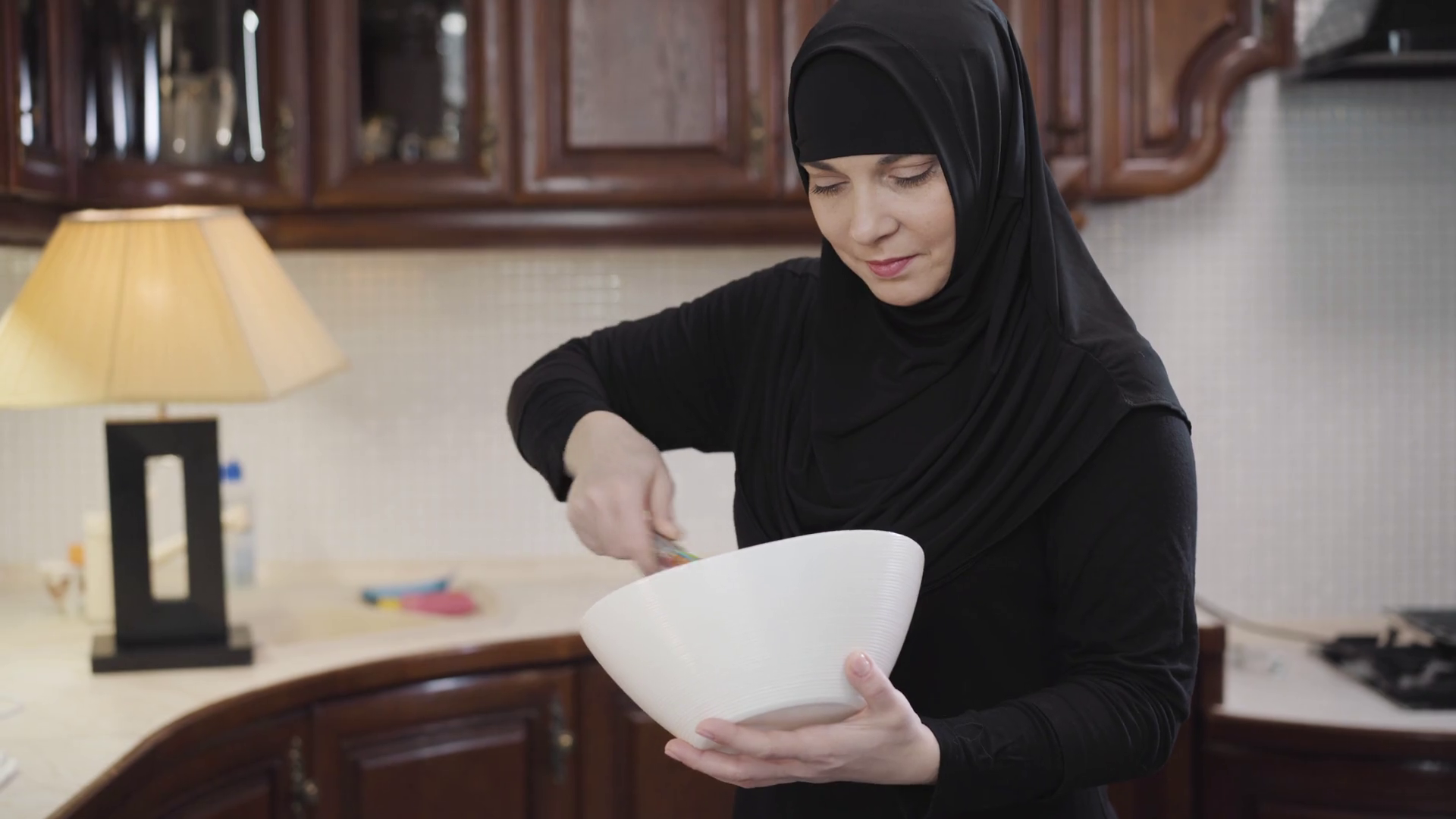 Portrait of diligent Muslim woman in traditional hijab standing at