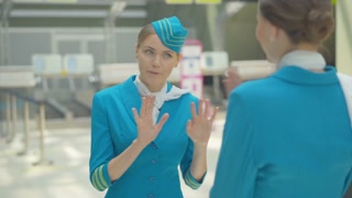 Portrait of enthusiastic young flight attendant bidding farewell to coworker and departing. Confident woman in uniform embarking on international travel. Professionalism and global tourism.