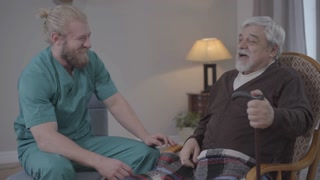 Positive interaction between male nurse and retiree in nursing home.