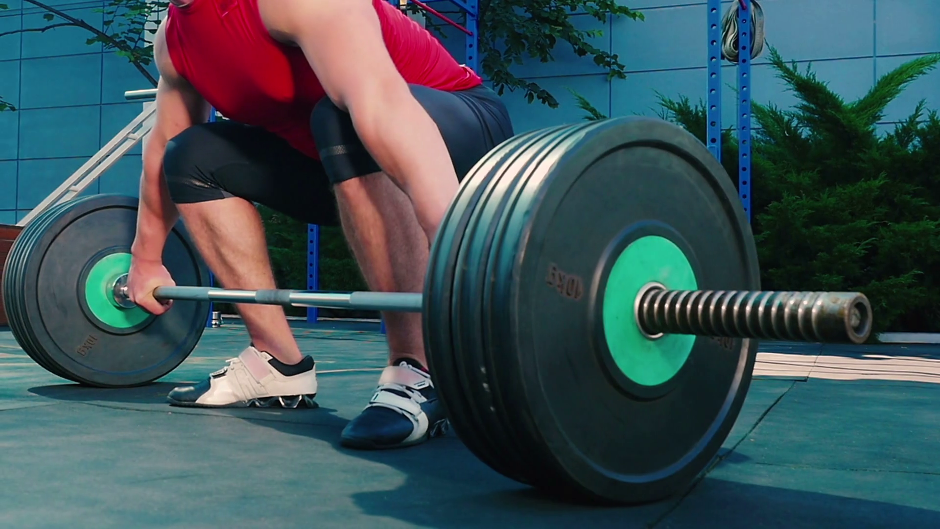 Sportsman raise up and throw down the barbell on the sports ground