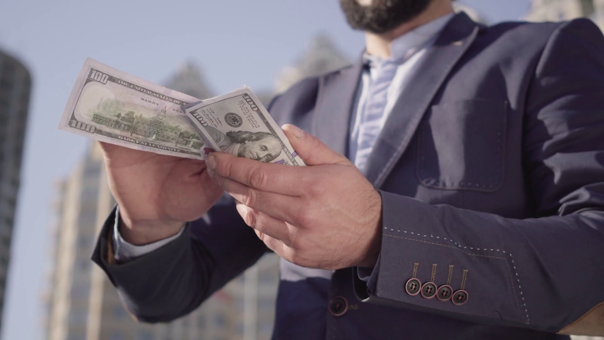 Unrecognizable bearded man in suit scattering money and laughing