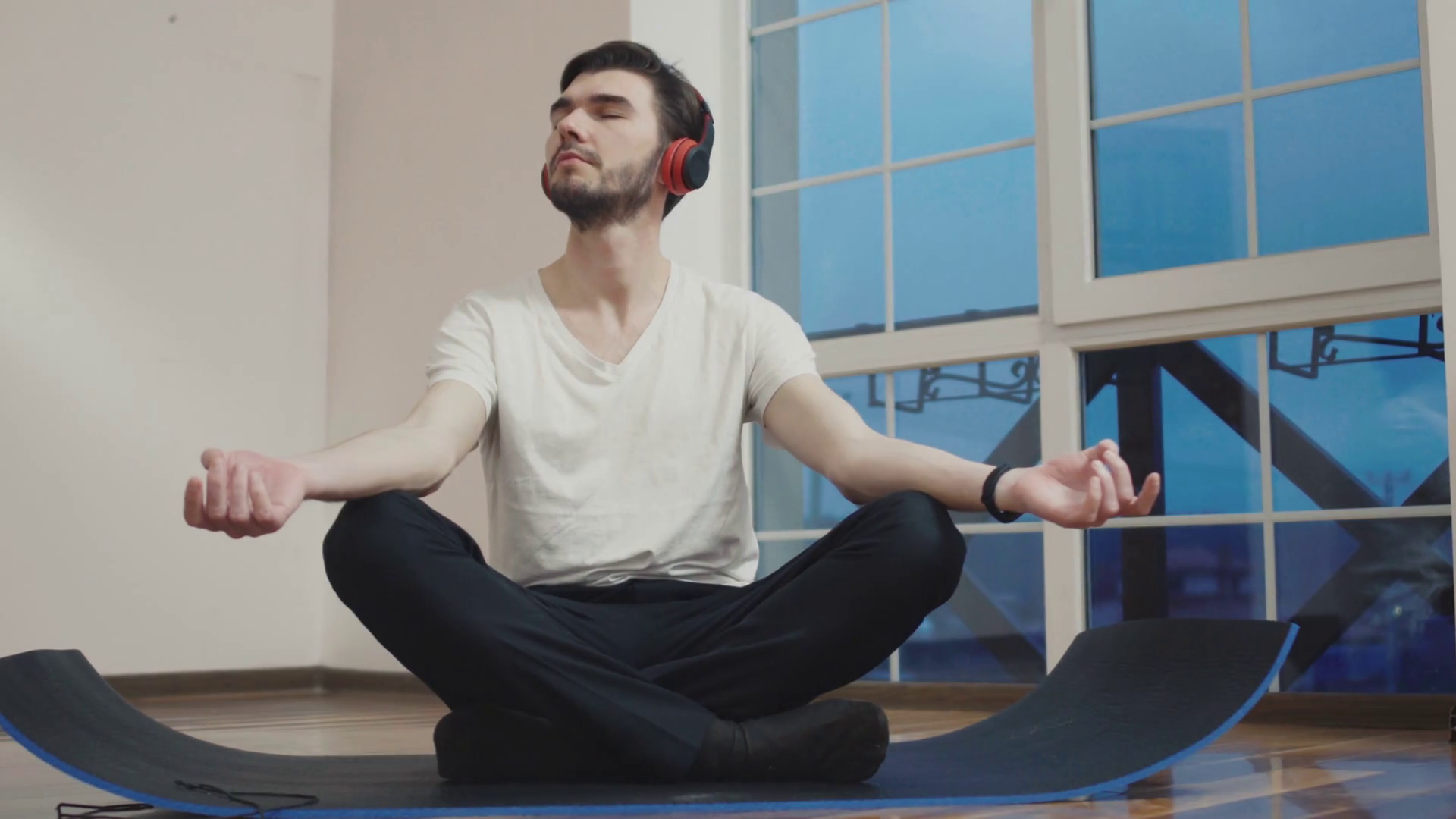 Young guy meditating on floor and listen music in headphones Stock Video Footage 0013 SBV