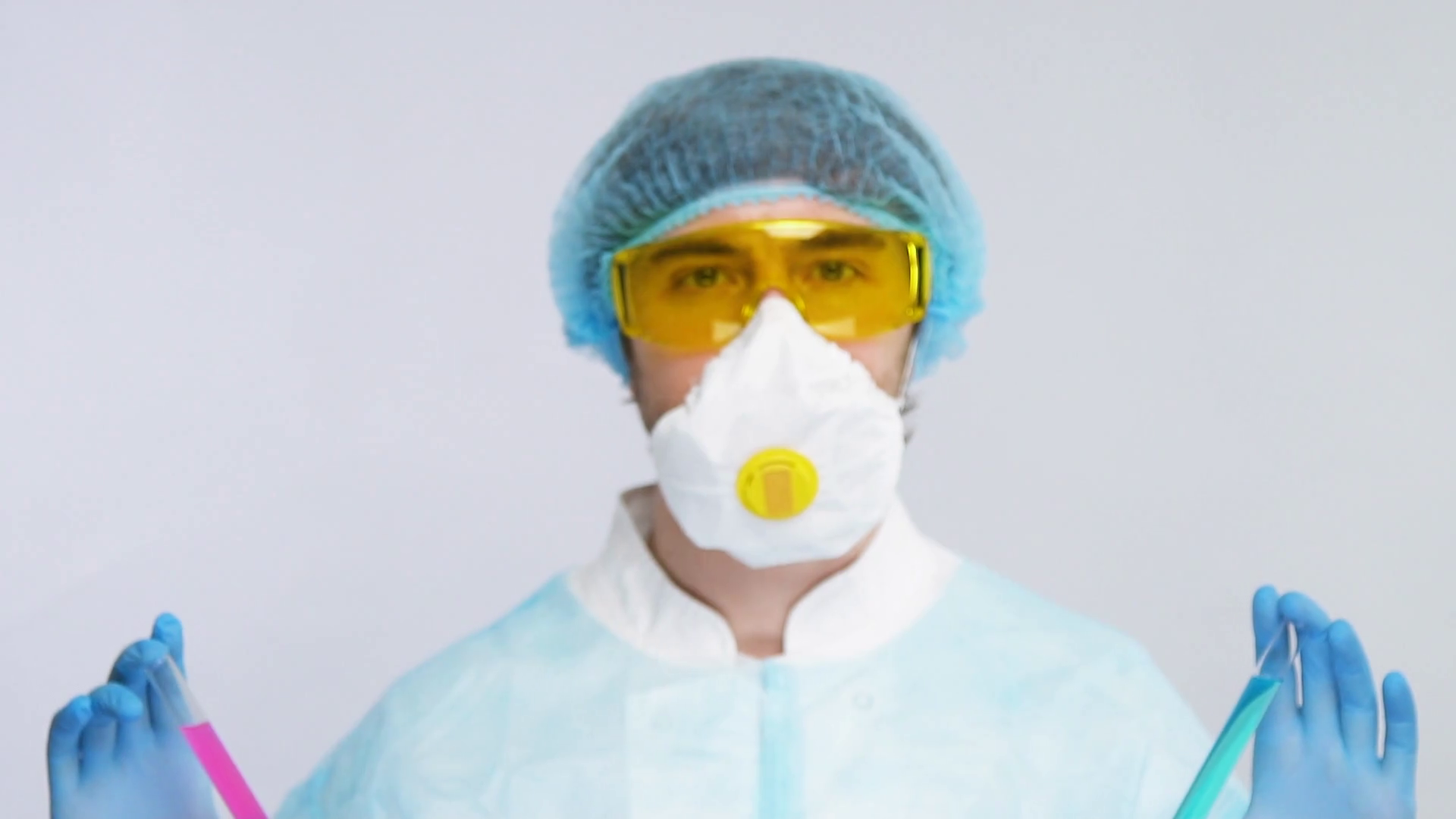 laborant in biohazard suit showing two sample of antivirus to covid19