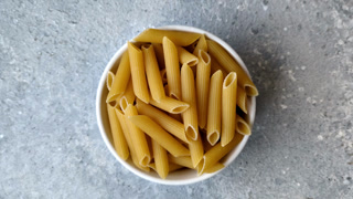 Italian uncooked dry penne regate pasta ready for cooking. Dry penne pasta