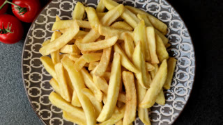 Crispy, fresh, golden French fries with salt, unhealthy takeaway food. French fries