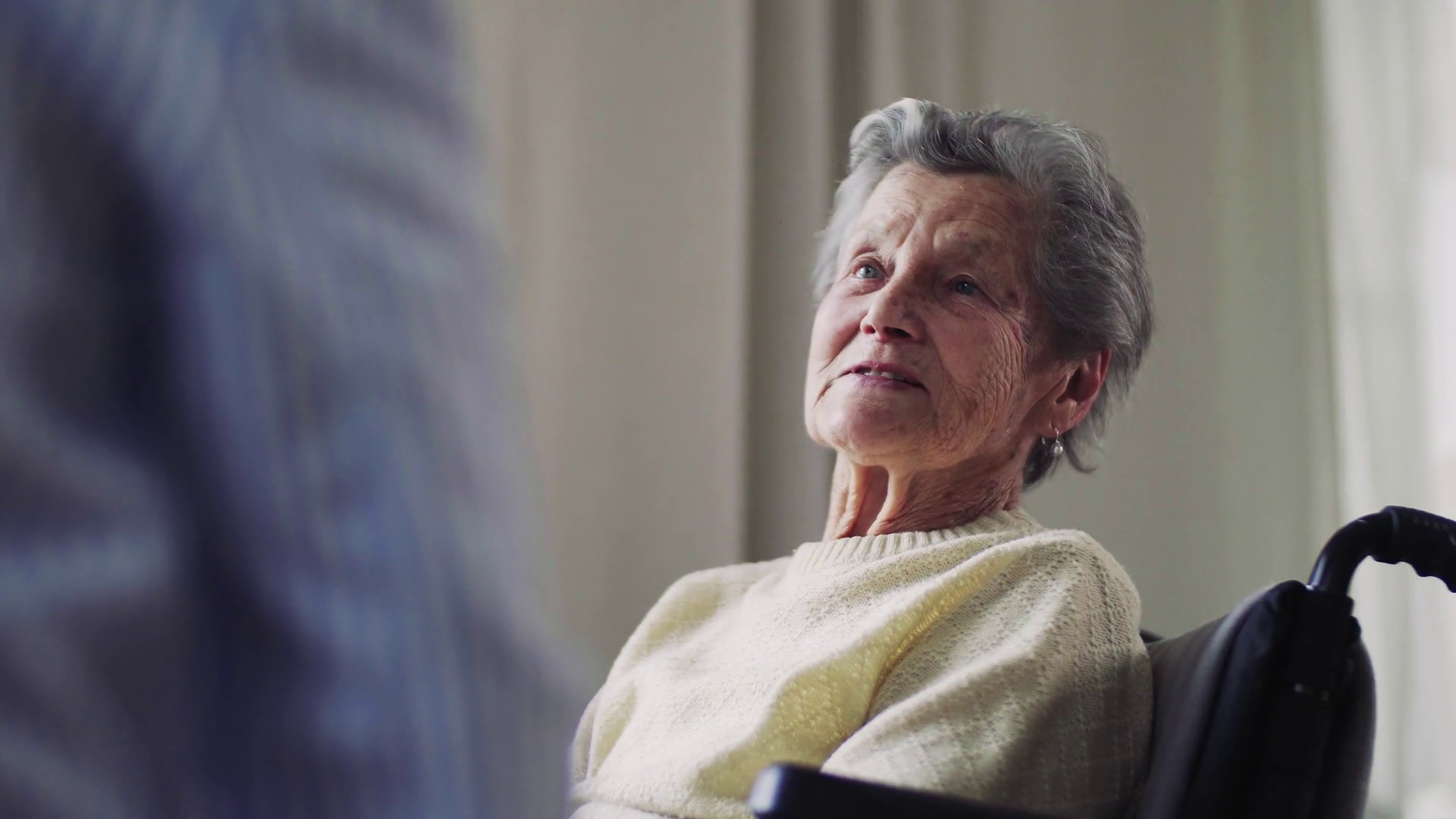 A Senior Woman In Wheelchair With An Unrecognizable Health Visitor At 