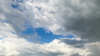 Heavenly beautiful cloudscape moving in the air. Fluffy white clouds in the rays of bright sun. Low angle timelapse.