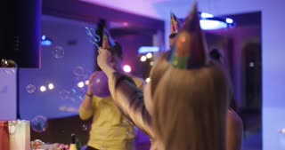 Friends Celebrating a Birthday with Balloons, Bubbles, and Joyful Festivities at a Colorful Party