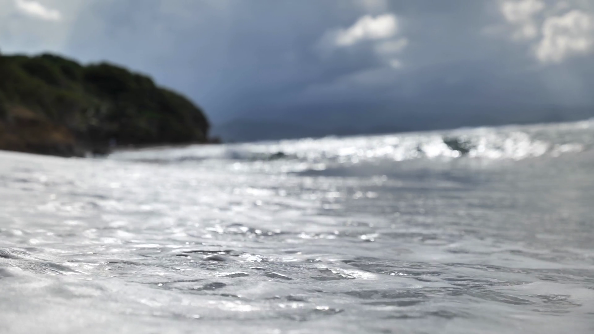 waves crashing on a beach in Martinique stormy clouds tropical weather
