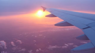 Window point of view of the sun in a plane, seeing wing aircraft. Location Paris early morning. 