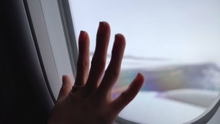 Close up woman passenger on window seat hand touch on airplane window inside the cabin with snowy outside runway, snowing airport, travelling on winter,  cold and lonely feeling, missing out and sad