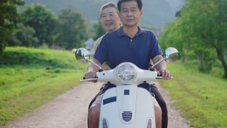 Elderly couple exploring a tropical island on a scooter, enjoying a beautiful natural travel destination together