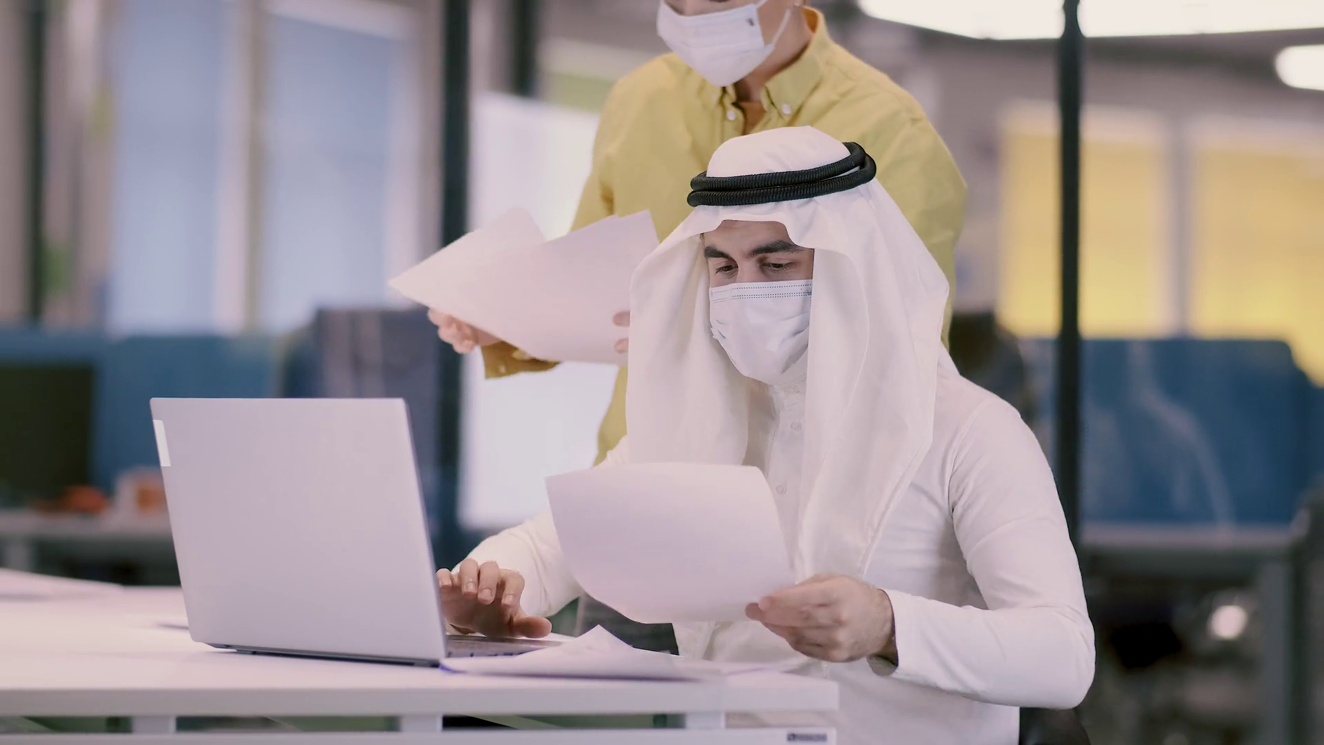 Workplace Of An Arab Businessman During A Pandemic A Man In Arabic Clothes And A Medical Mask Works In The Office On A Laptop Work Colleagues Observe Safety Precautions Stock Video Footage