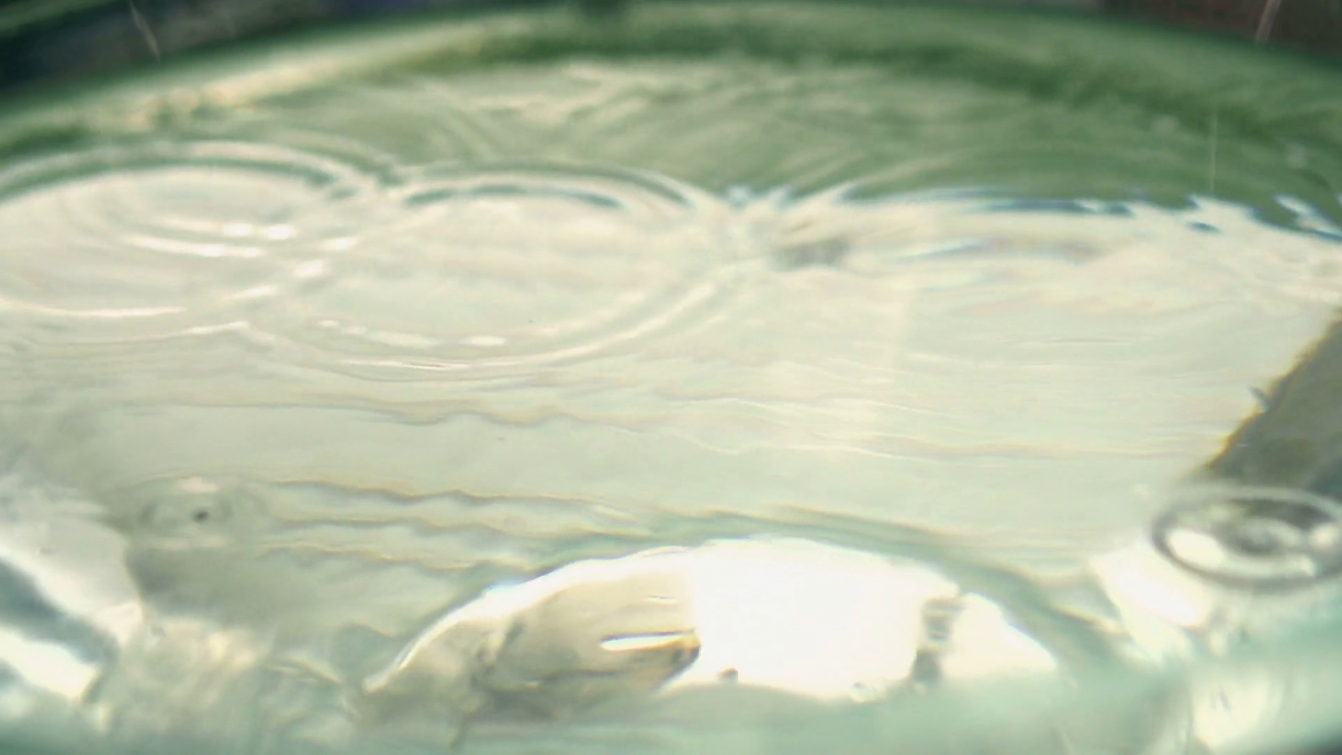 Raindrops falling into water, closeup, slow motion shot at 240fps Stock