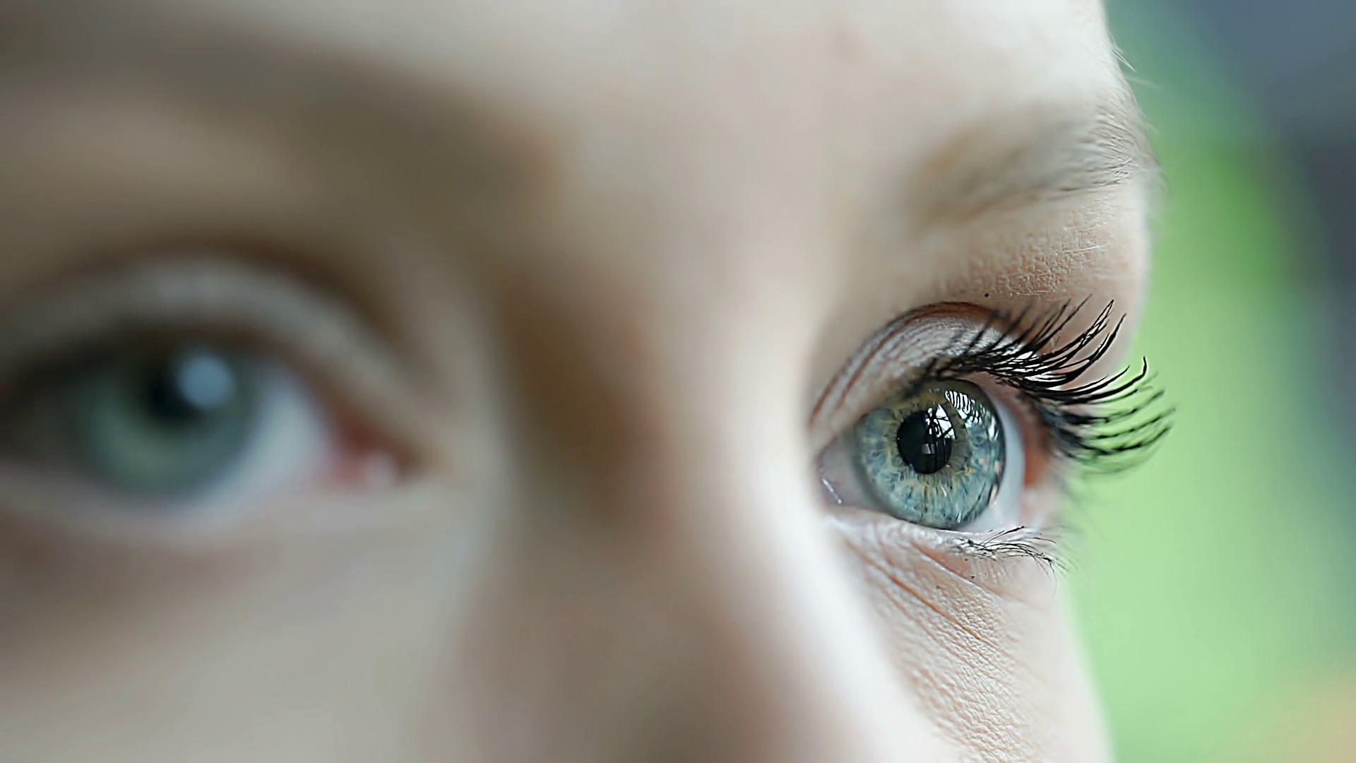 View of girl's beautiful blue eyes which are moving in all directions