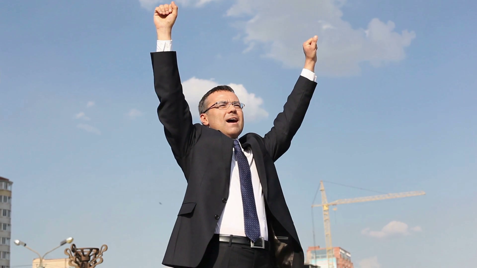 Successful businessman standing with his hands held high in excitement