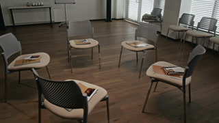 Background shot of support group therapy room with focus on chairs set in circle and promotional materials for each participant, copy space